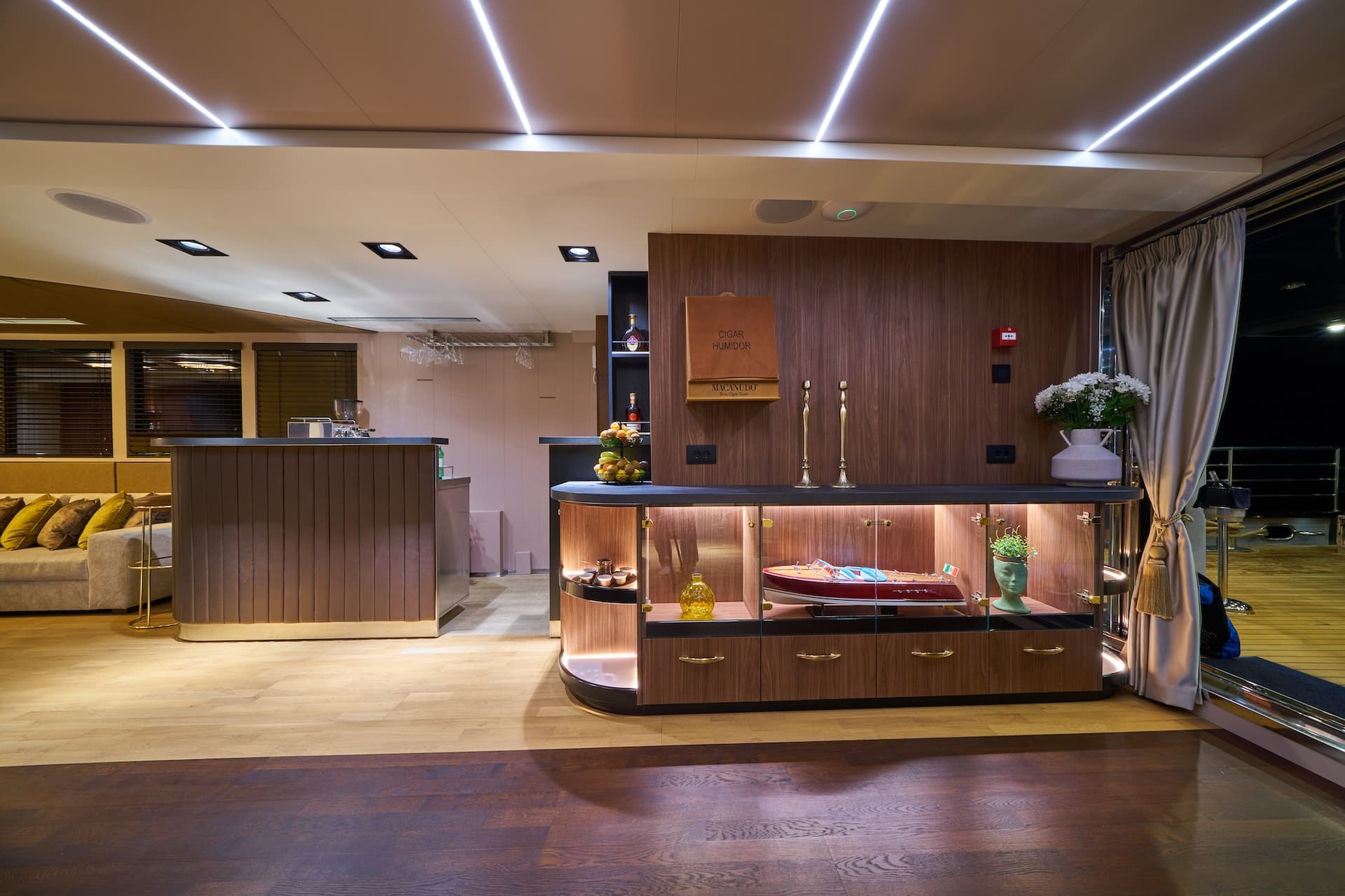 Luxury yacht interior bar area with illuminated display case and modern lighting.