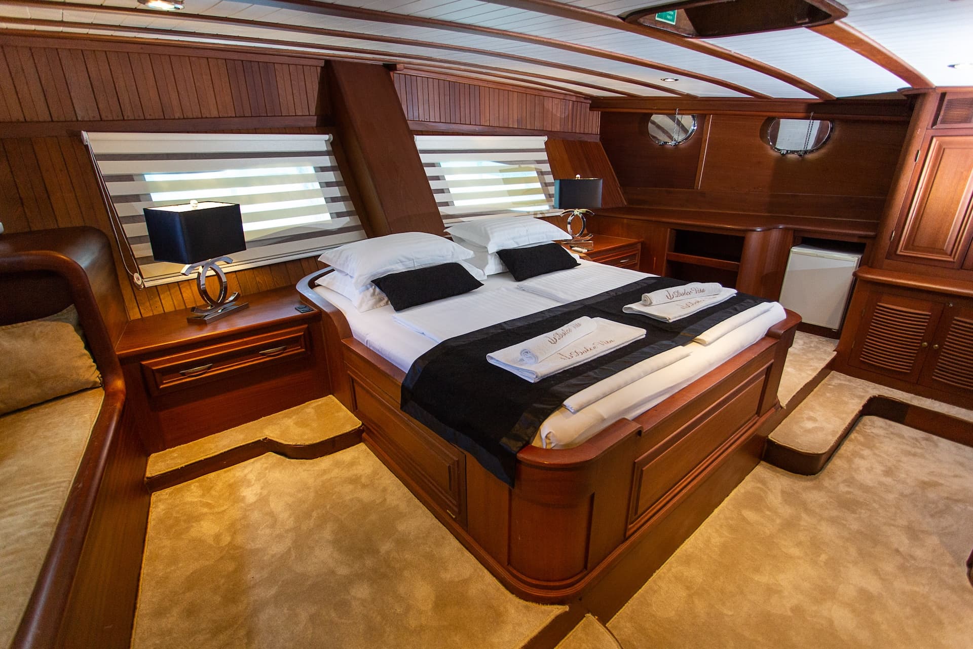 Master bedroom ensuite cabin with wood paneling, plush carpet, and queen bed on Dolce Vita.