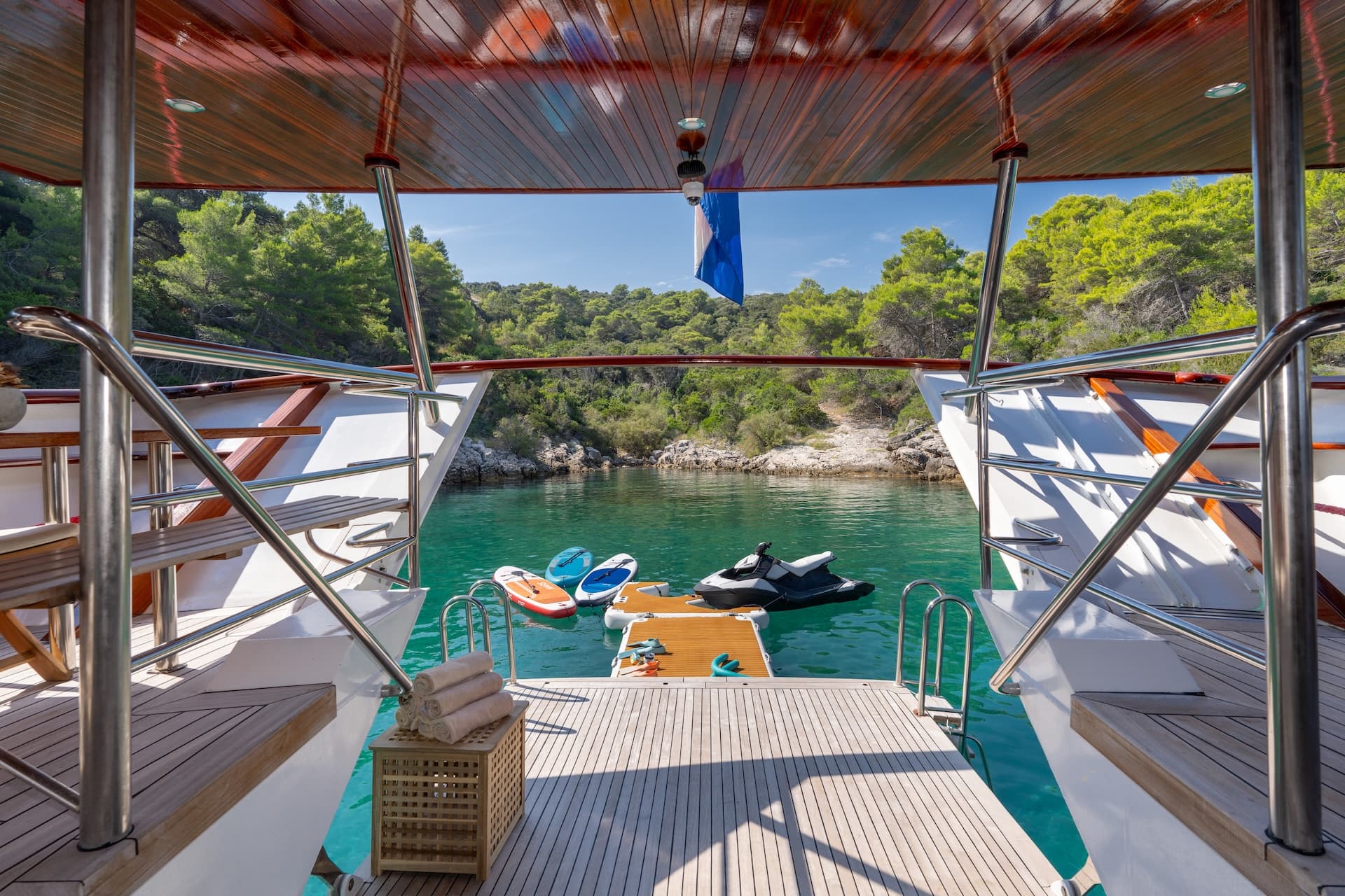 View from Gulet Barbara stern showing turquoise cove with paddleboards and jet ski.