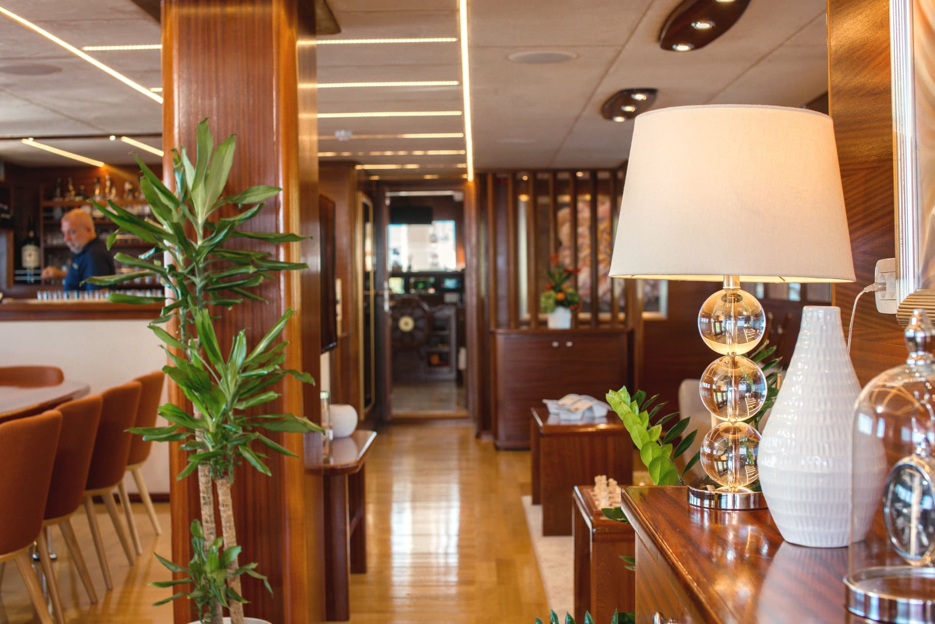 Hallway corridor interior with wood paneling, glossy floor, and a decorative lamp.