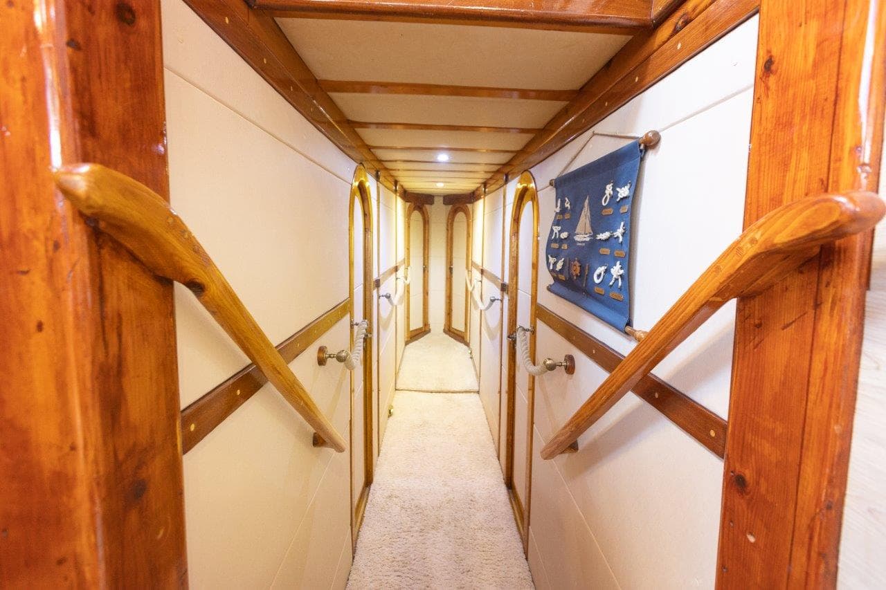 Nautical interior hallway with wood trim, white walls, and a blue nautical knot display banner.