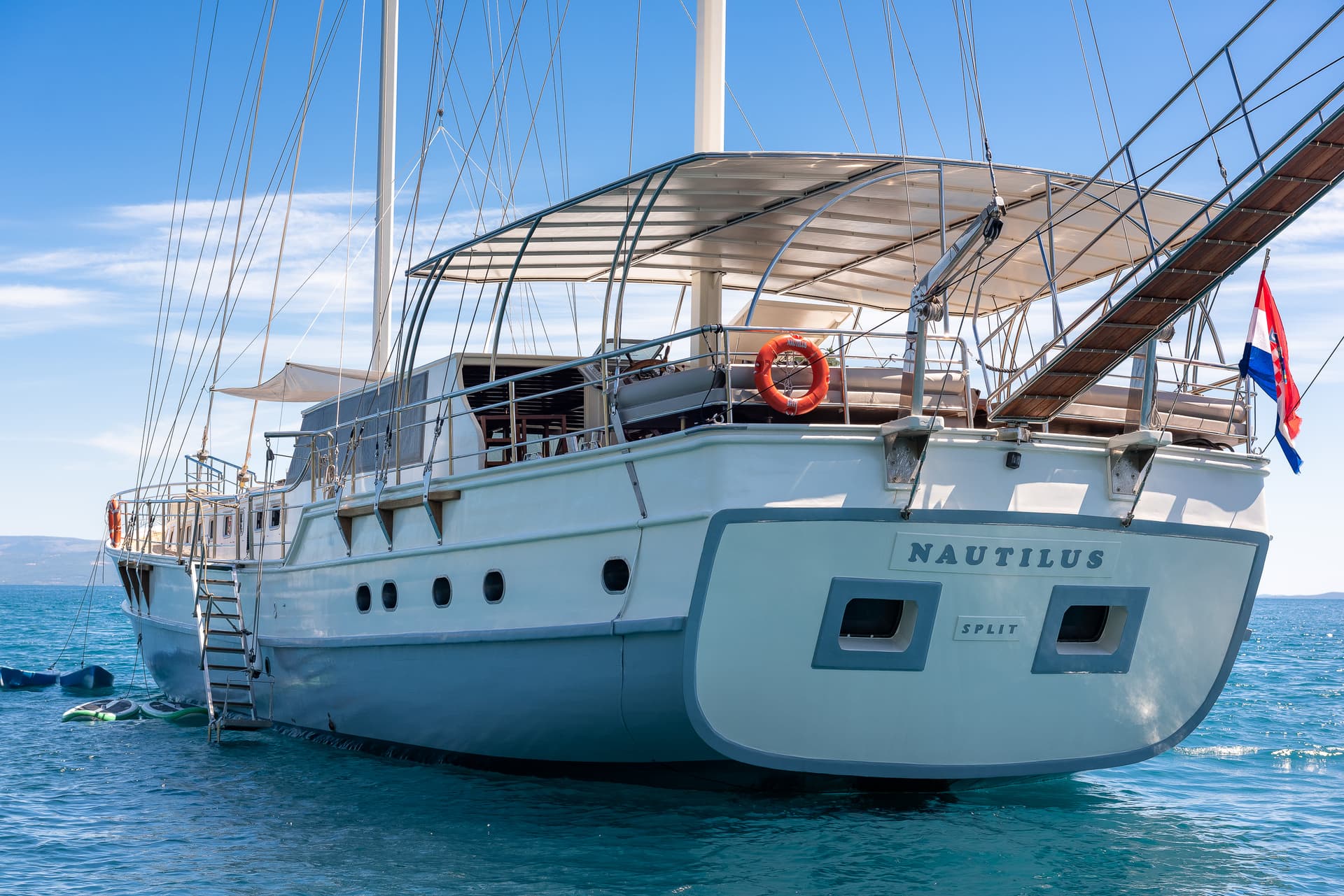 Motor yacht Nautilus docked in blue water, displaying "SPLIT" and Croatian flag.