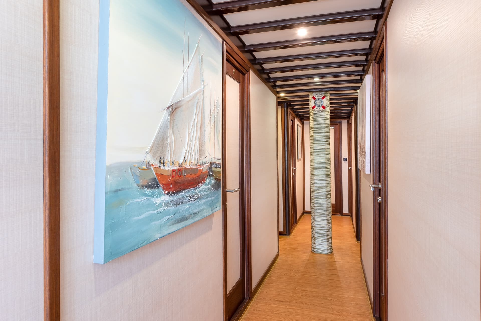 Nautical hallway with boat painting, wood trim, and life preserver decoration