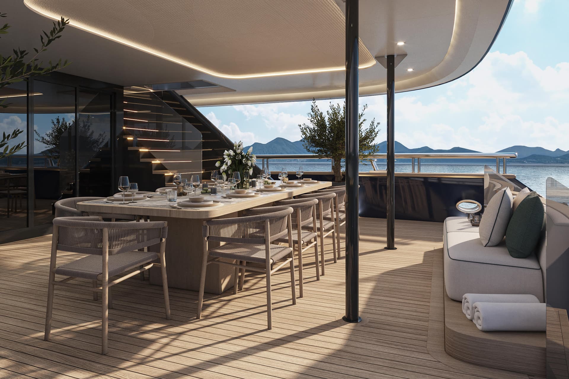 Luxury yacht deck with dining table and chairs overlooking sea and mountains