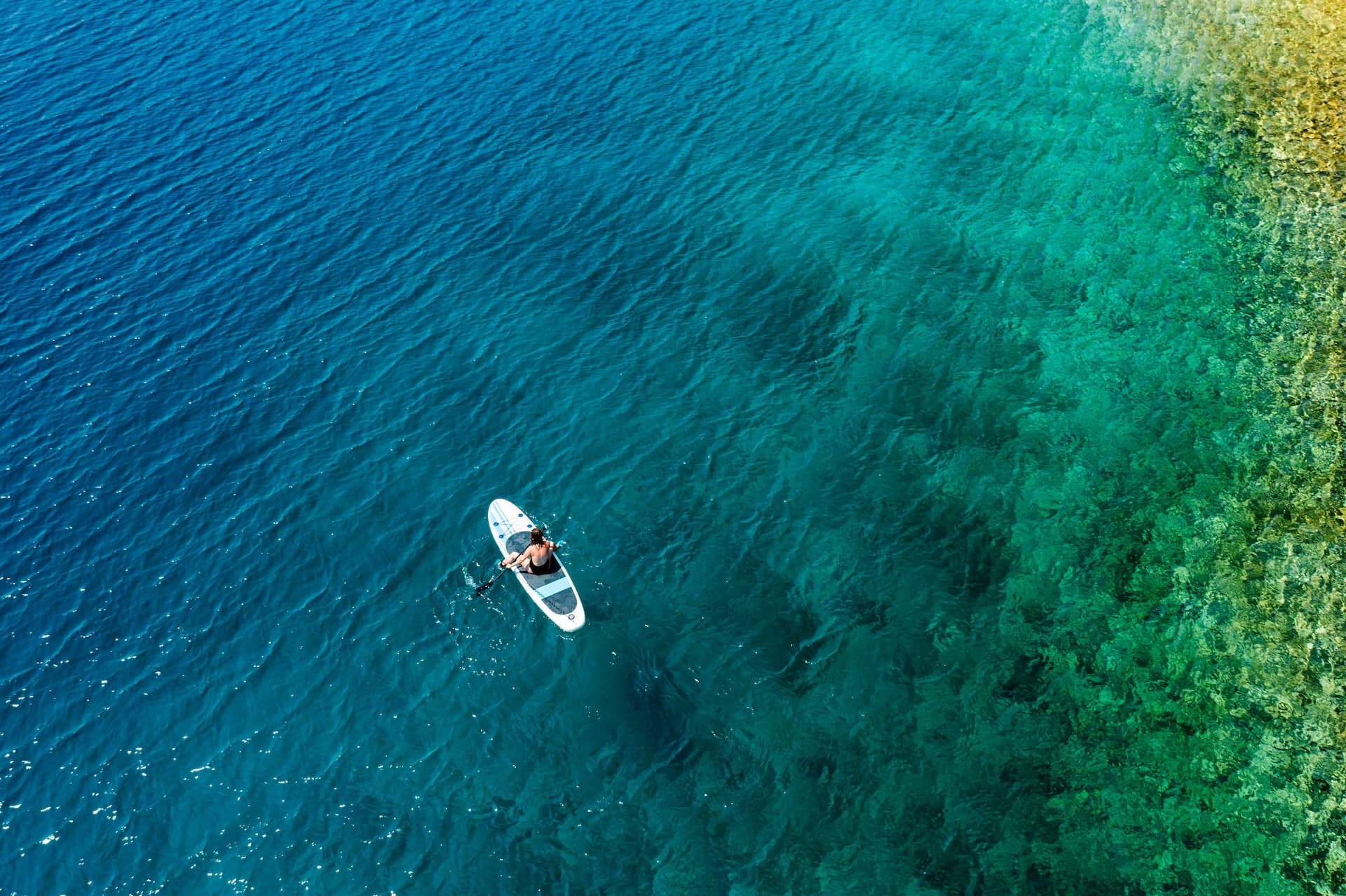 Stand-up paddleboarding on clear blue and green coastal waters near Lopud.